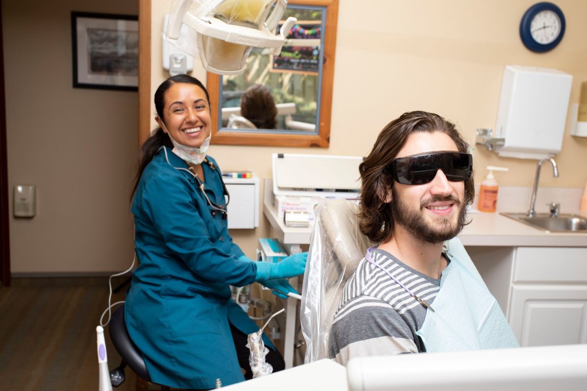Busk dental assistant smiling with a patient